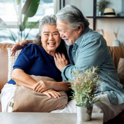 old senior asian retired couple enjoy talking conversation together on sofa with happiness laugh smile and joyful at home,asian old mature adult stay home quarantine period concept